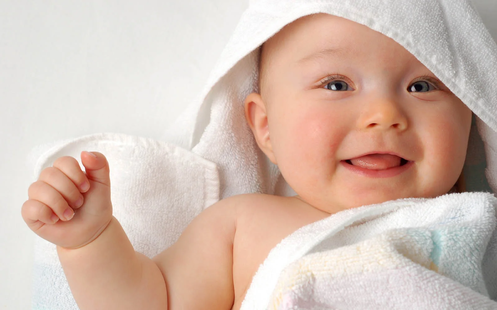 Khuôn mặt em bé quấn khăn trắng cười toe toét