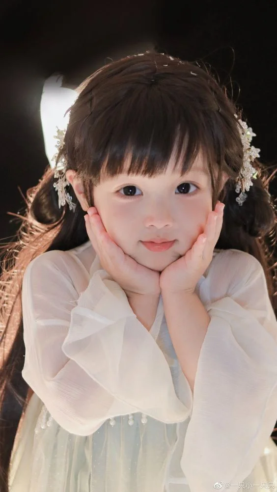 Hình ảnh em bé gái mặc váy trắng tựa cằm pose ảnh nghệ thuật ánh sáng