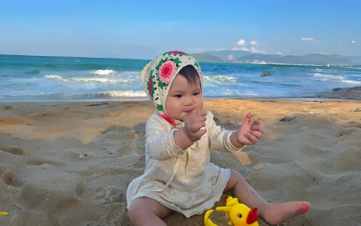 Bé vui chơi với đồ chơi và cát tại bãi biển
