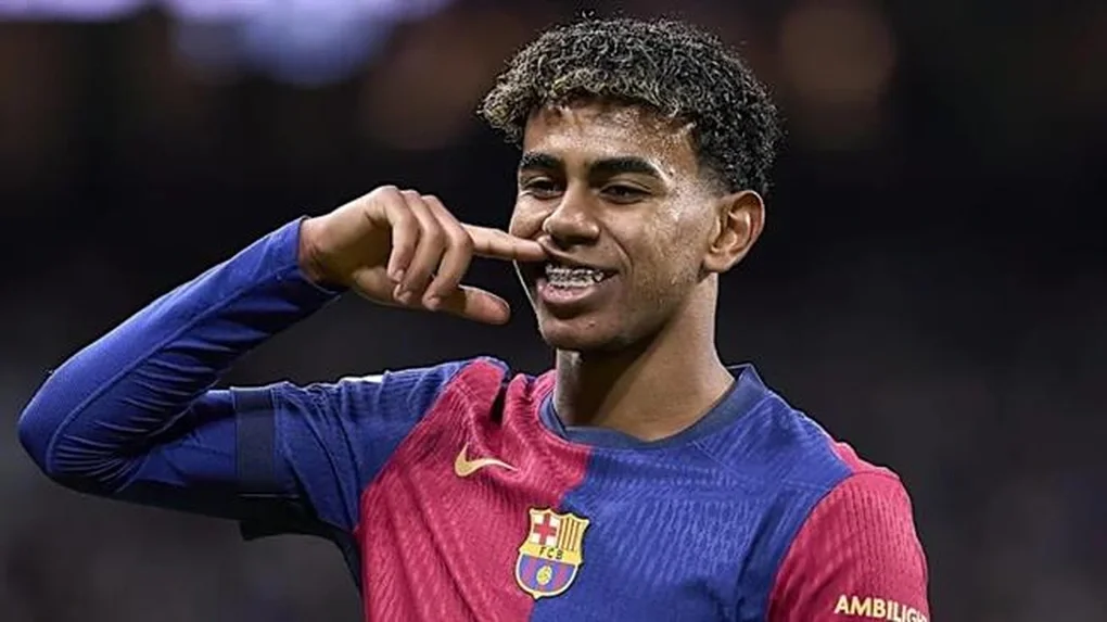 Ảnh Lamine Yamal đang mỉm cười ăn mừng trên sân cỏ trong trang phục thi đấu của FC Barcelona.
