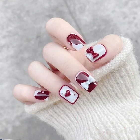 Mẫu móng tay đẹp phối màu đỏ trắng với họa tiết nơ và trái tim 3D thời thượng